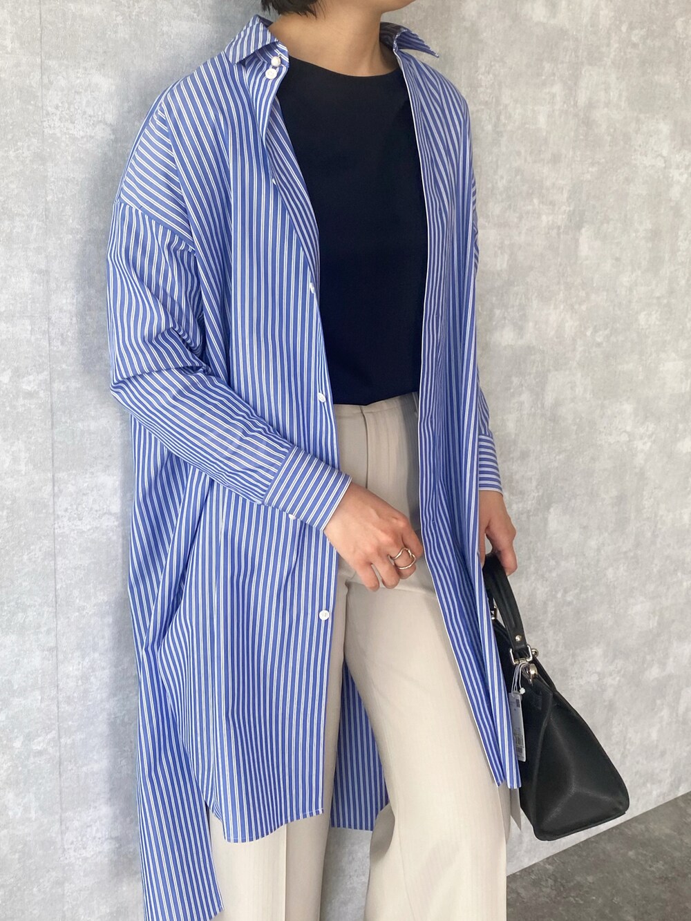 ブルー系のシャツワンピース、ブルー系のTシャツ/カットソー、ベージュ系のパンツを着用したレディースの春コーディネートの3枚目の写真