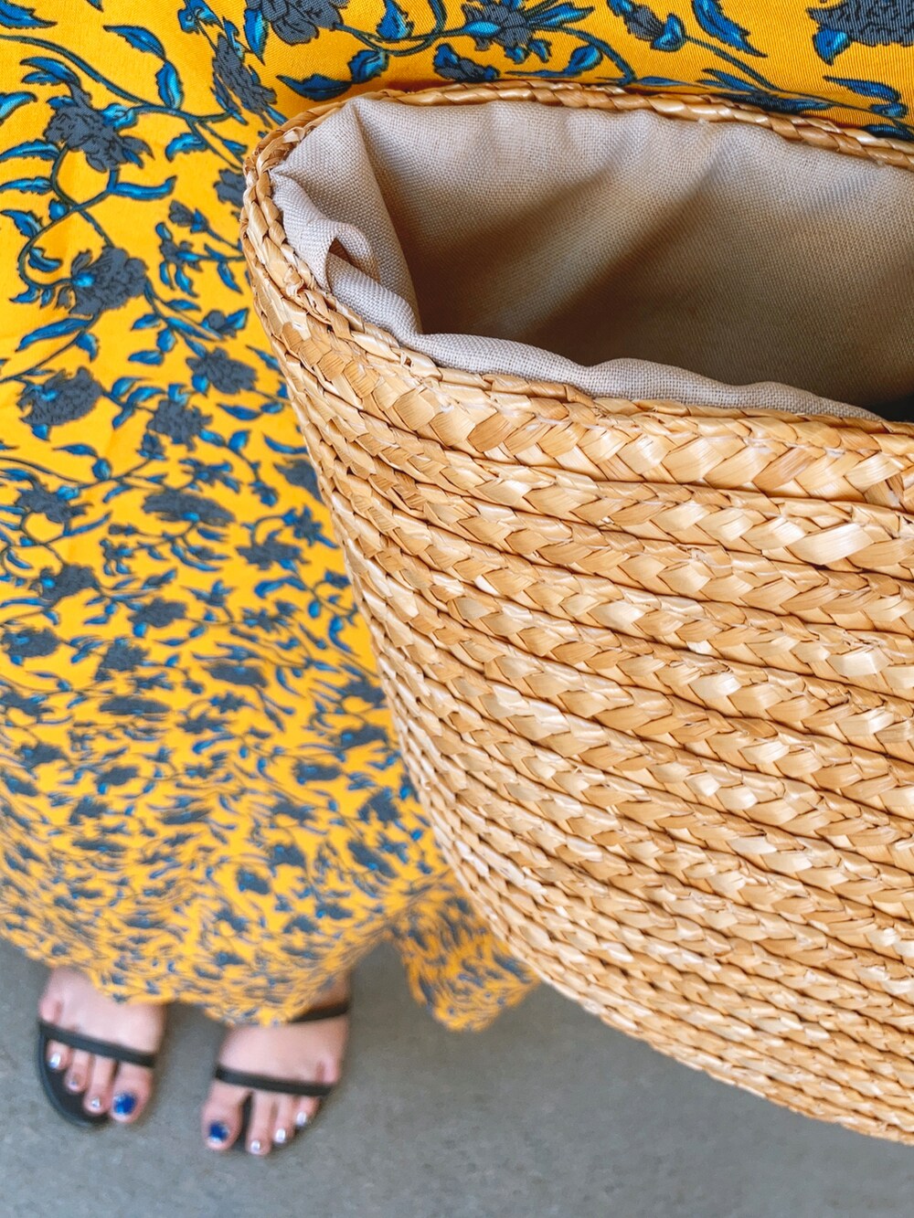 イエロー系のワンピース、ベージュ系のかごバッグを着用したレディースの夏コーディネートの2枚目の写真