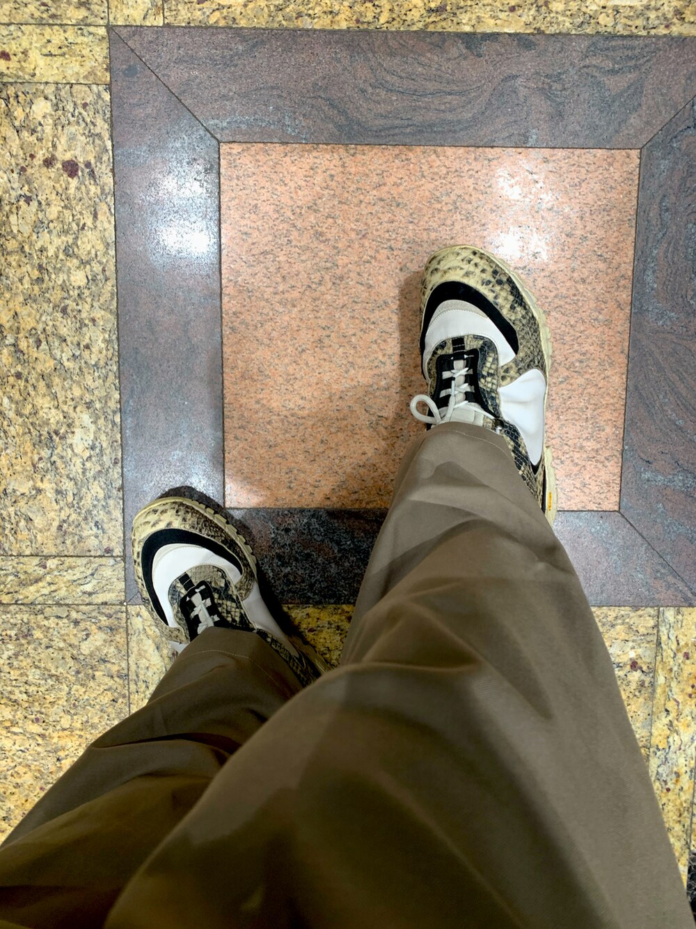 ホワイト系のトップス、ブラック系の帽子を着用したメンズの春コーディネートの2枚目の写真