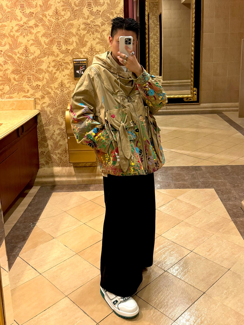 ベージュ系のジャケット/アウター、ブラック系のパンツ、ホワイト系のシューズを着用したメンズの冬コーディネートの2枚目の写真