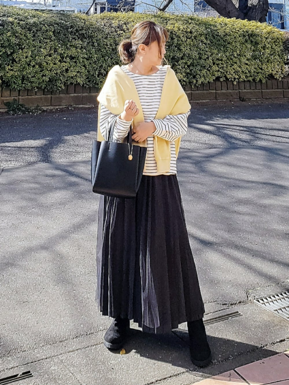 ホワイト系のTシャツ/カットソー、ブラック系のトートバッグ、グレー系のスカートを着用したレディースの冬コーディネートの2枚目の写真