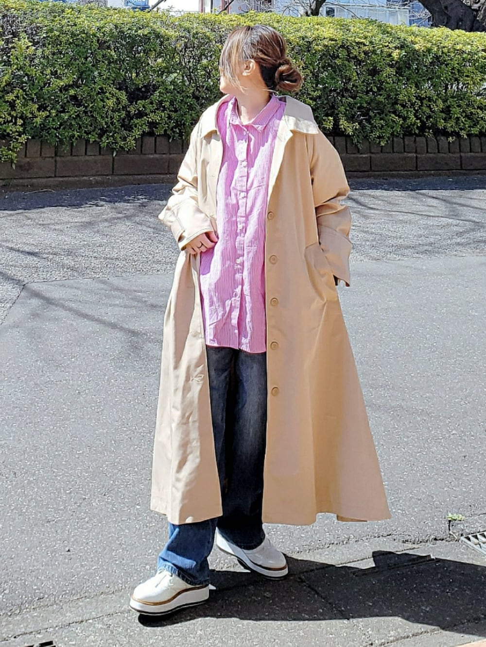 パープル系のシャツ/ブラウス、ベージュ系のステンカラーコート、ブルー系のデニムパンツを着用したレディースの春コーディネートの2枚目の写真