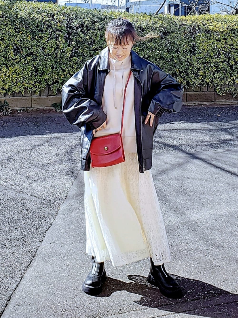 ブラック系のブルゾン、ベージュ系のスウェット、ホワイト系のスカートを着用したレディースの春コーディネートの3枚目の写真