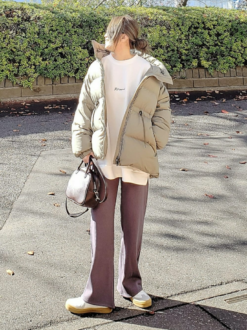 グリーン系のダウンジャケット/コート、ホワイト系のスウェット、グレー系のその他パンツを着用したレディースの冬コーディネートの3枚目の写真