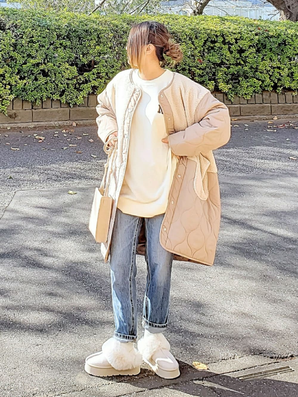 ホワイト系のその他アウター、ホワイト系のスウェット、ブルー系のデニムパンツを着用したレディースの冬コーディネートの2枚目の写真