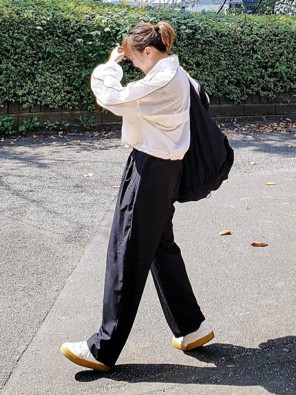 ホワイト系のブルゾン、ブラック系のスラックス、ブラック系のTシャツ/カットソーを着用したレディースの秋コーディネートの3枚目の写真