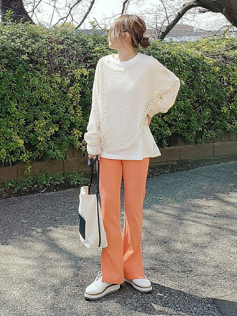 ベージュ系のニット/セーター、オレンジ系のその他パンツ、ホワイト系のローファーを着用したレディースの春コーディネートの2枚目の写真