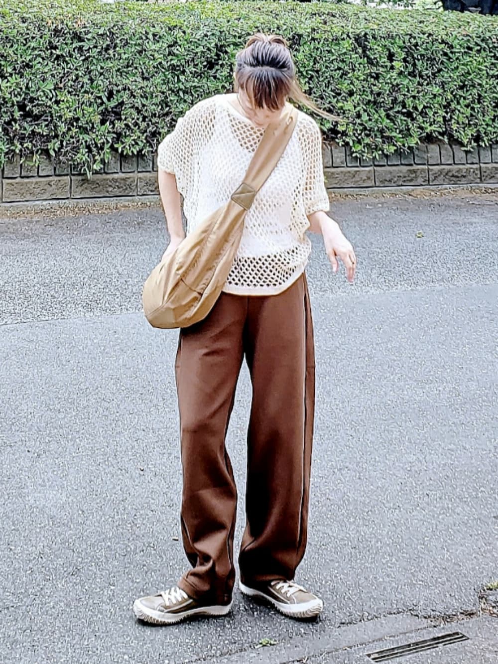 ベージュ系のニット/セーター、ブラウン系のスウェットパンツ、グレー系のスニーカーを着用したレディースの夏コーディネートの2枚目の写真