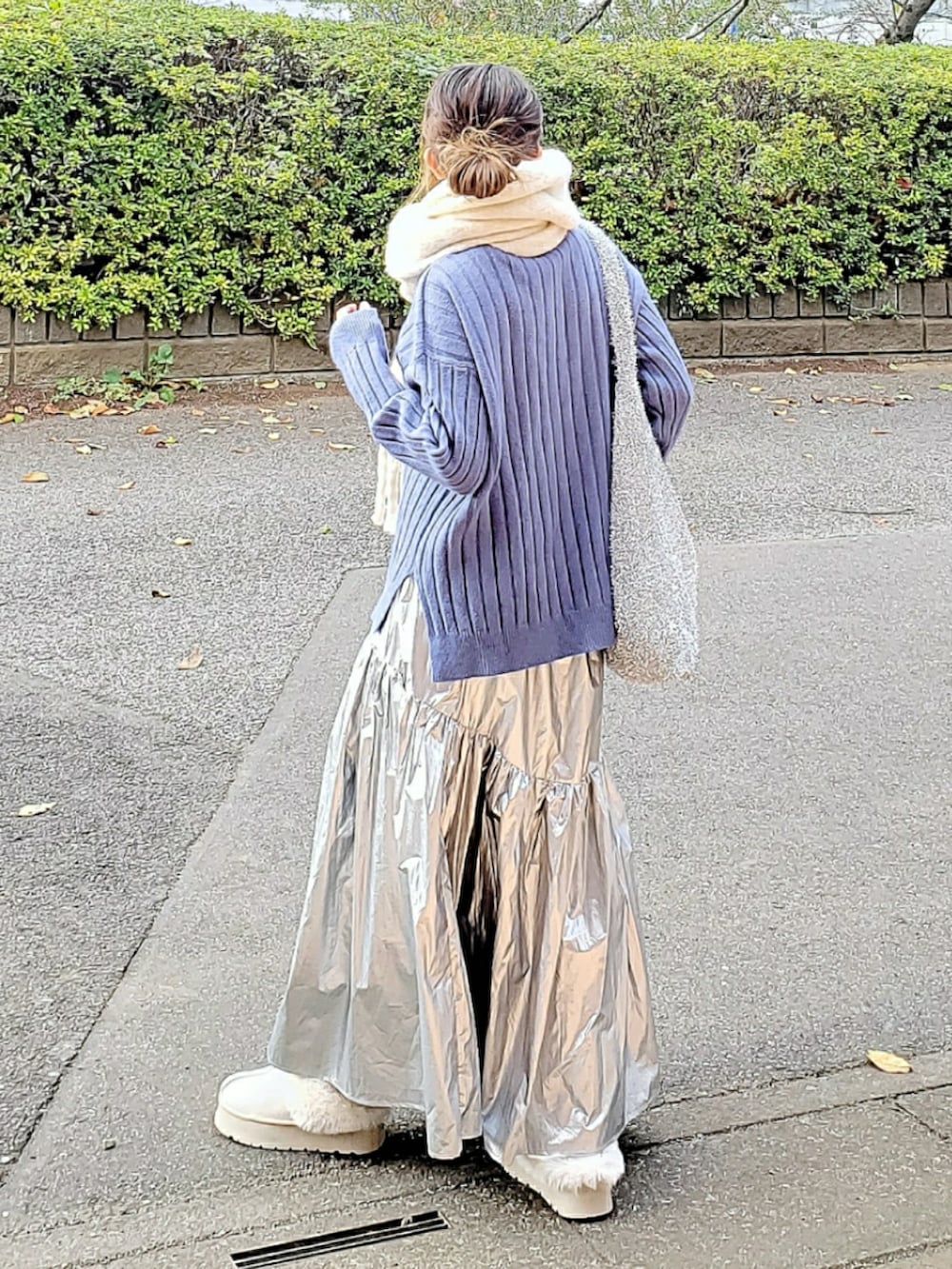 ブルー系のニット/セーター、シルバー系のスカート、ベージュ系のスリッポンを着用したレディースの冬コーディネートの3枚目の写真