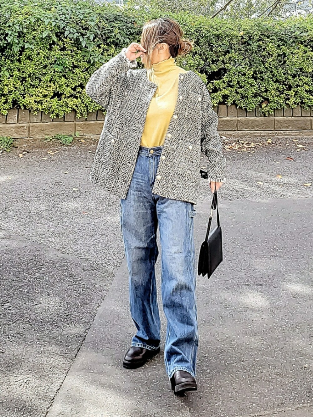 ブラック系のノーカラージャケット、ブルー系のデニムパンツ、ブラウン系のブーツを着用したレディースの秋コーディネートの2枚目の写真