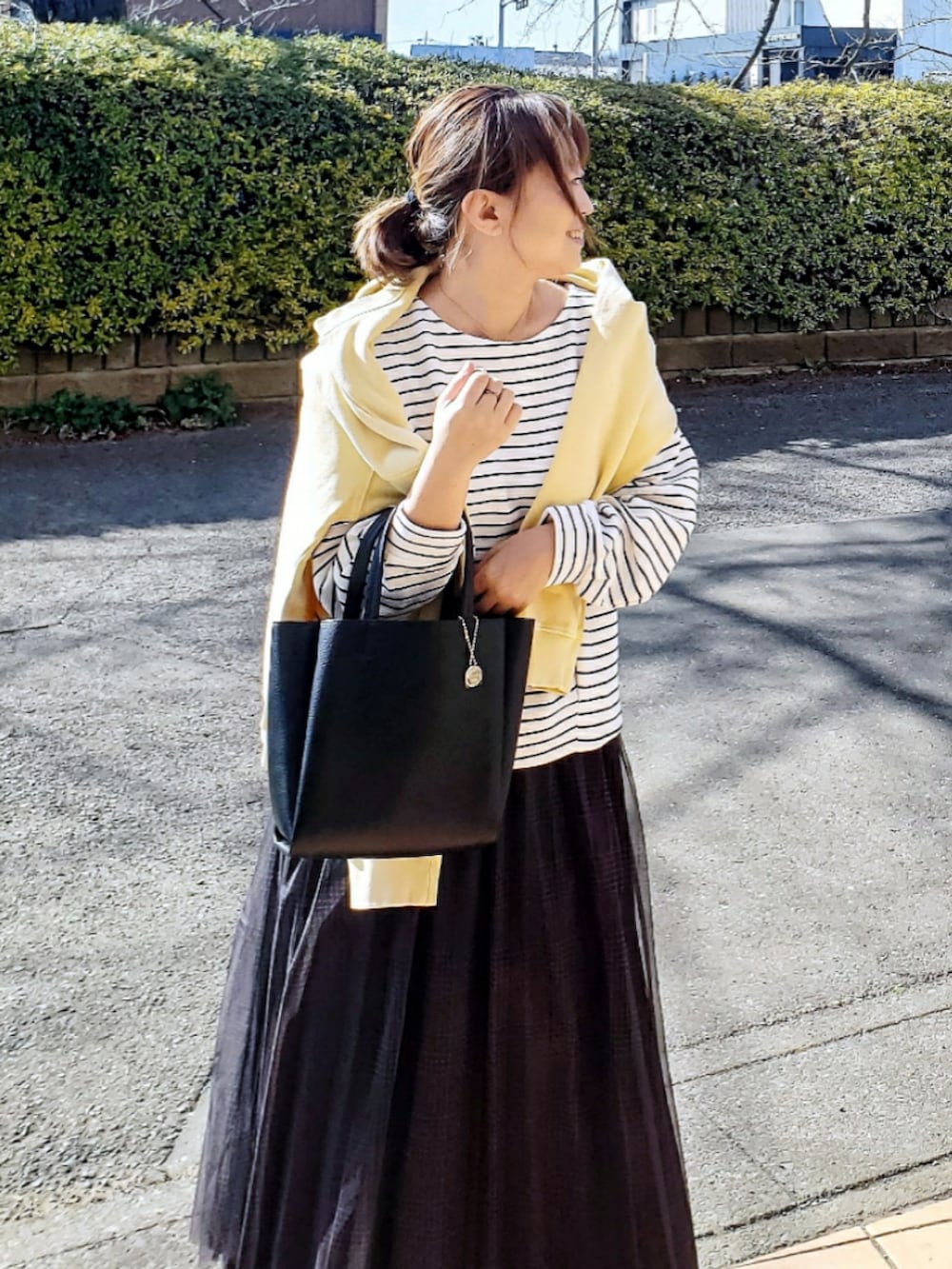 ホワイト系のTシャツ/カットソー、ブラック系のトートバッグ、グレー系のスカートを着用したレディースの冬コーディネートの4枚目の写真