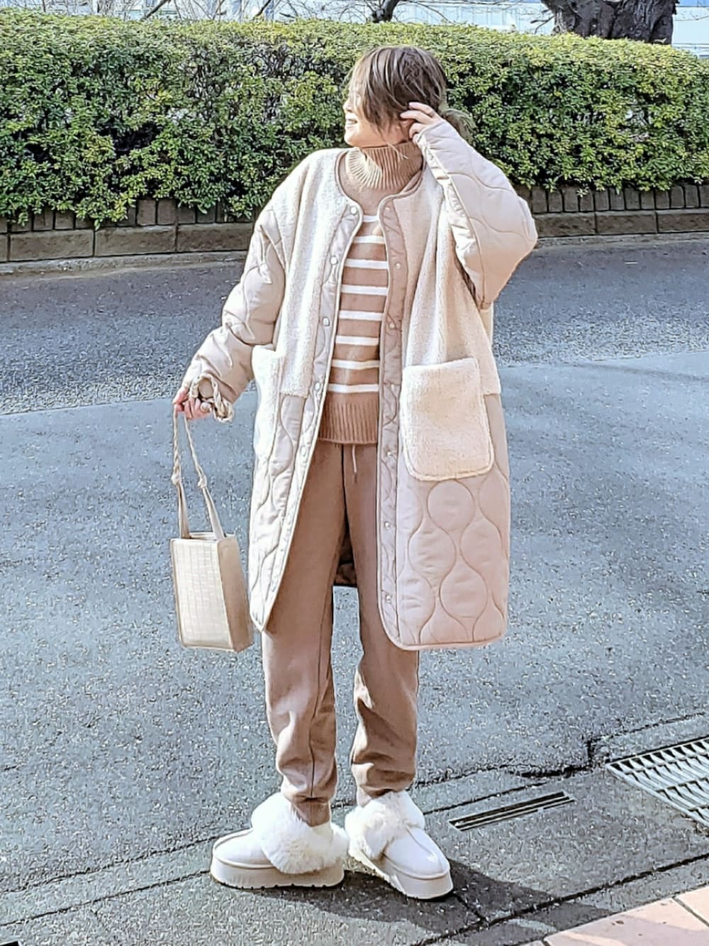 ホワイト系のその他アウター、ベージュ系のニット/セーター、ベージュ系のスウェットパンツを着用したレディースの冬コーディネートの2枚目の写真