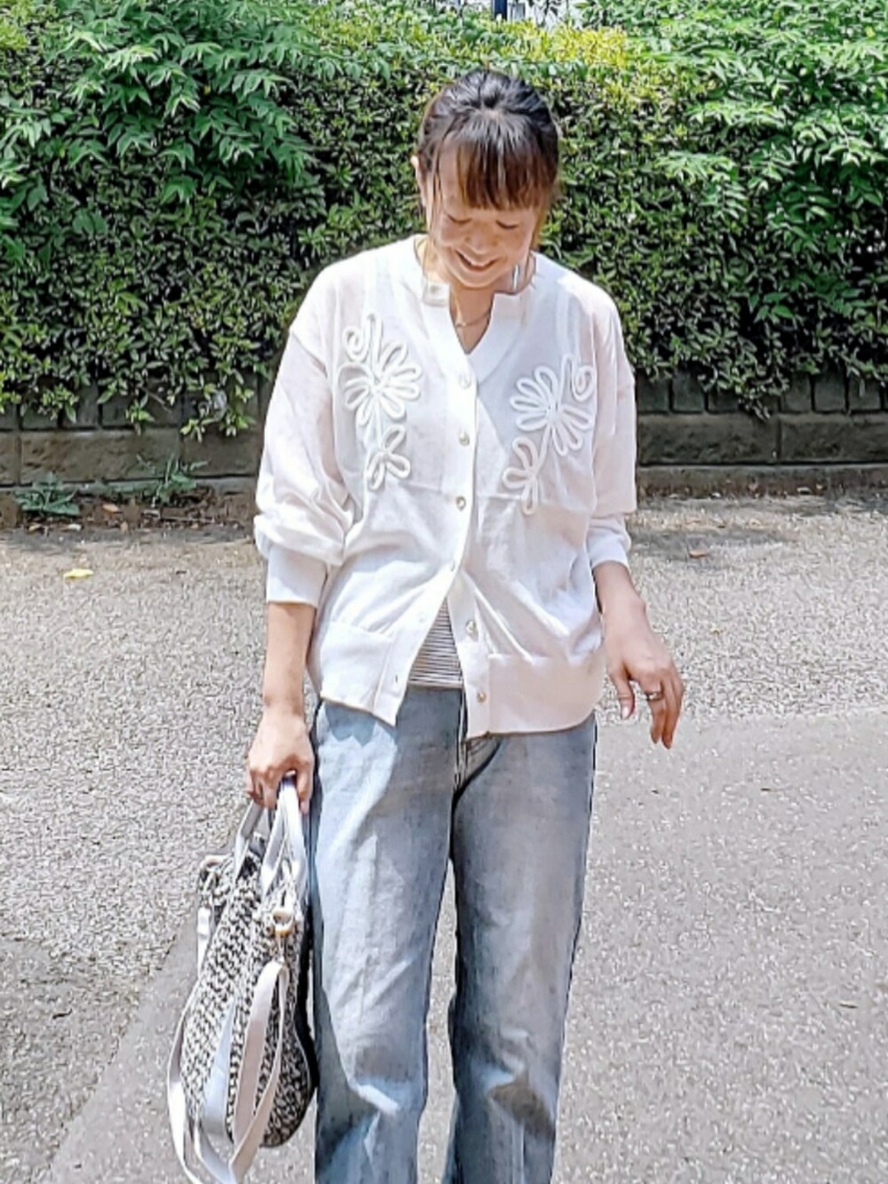 ホワイト系のカーディガン/ボレロ、ブルー系のデニムパンツ、グレー系のショルダーバッグを着用したレディースの夏コーディネートの3枚目の写真
