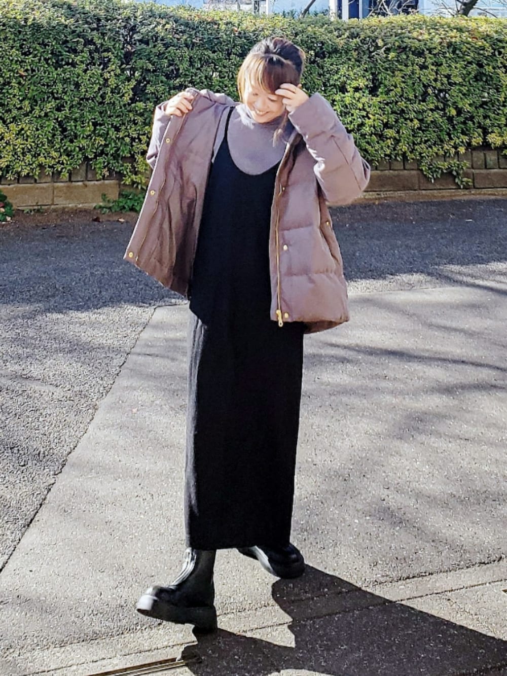 ブラウン系のダウンジャケット/コート、グレー系のニット/セーター、ブラック系のワンピースを着用したレディースの冬コーディネートの2枚目の写真