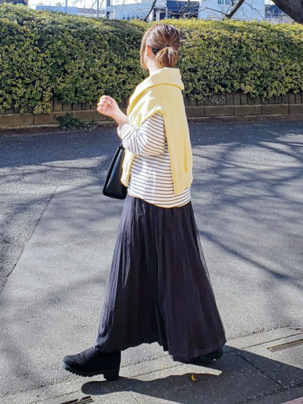 ホワイト系のTシャツ/カットソー、ブラック系のトートバッグ、グレー系のスカートを着用したレディースの冬コーディネートの3枚目の写真