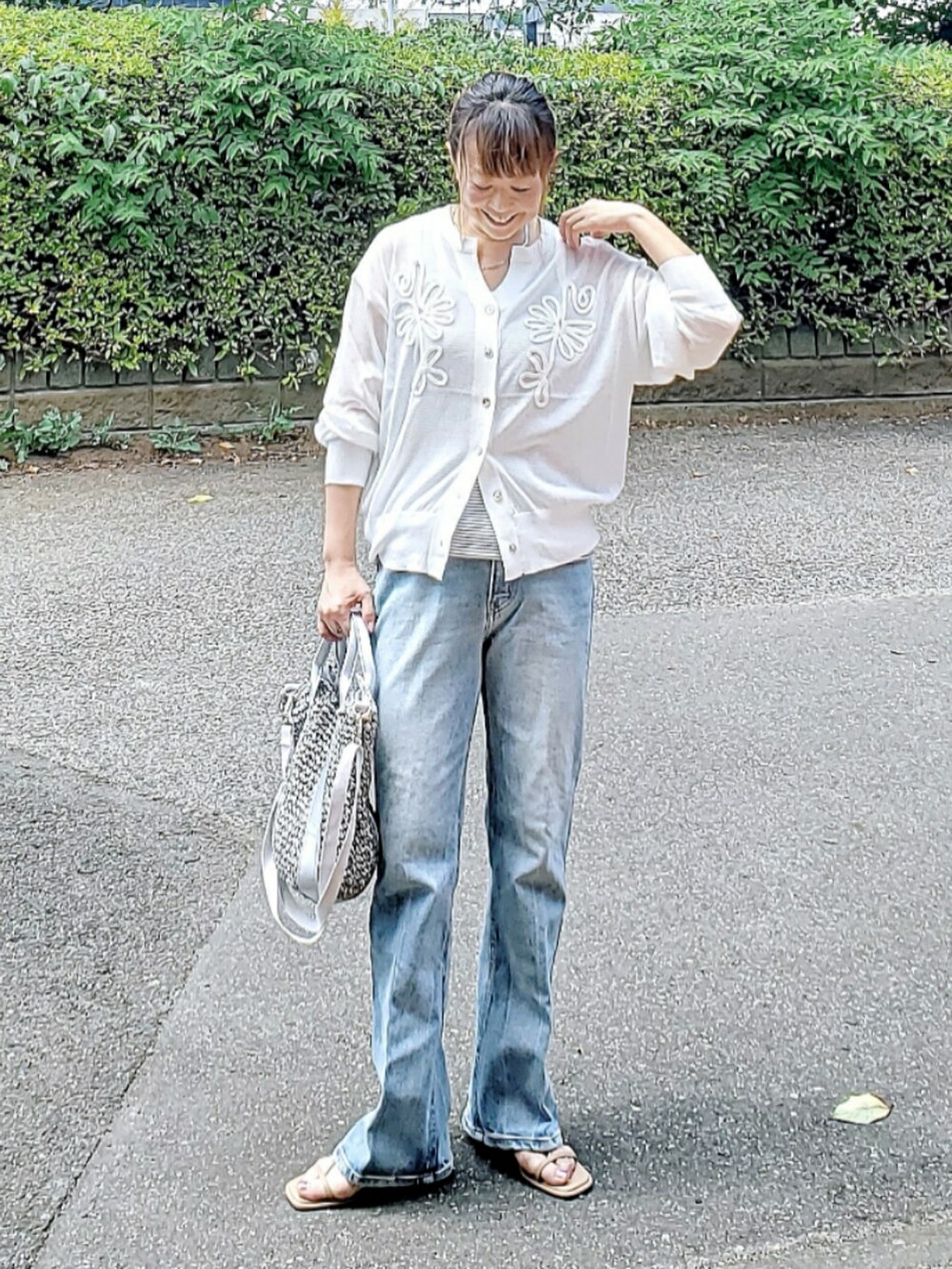 ホワイト系のカーディガン/ボレロ、ブルー系のデニムパンツ、グレー系のショルダーバッグを着用したレディースの夏コーディネートの2枚目の写真