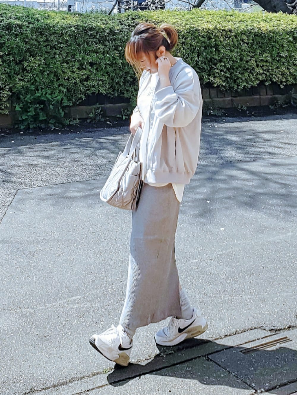 グリーン系のブルゾン、ホワイト系のTシャツ/カットソー、グレー系のスカートを着用したレディースの春コーディネートの3枚目の写真
