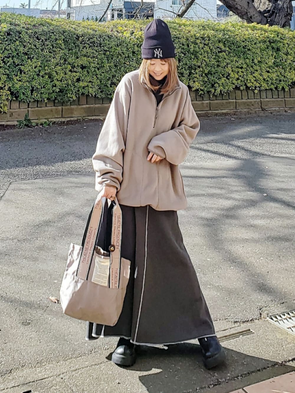 ブラウン系のトップス、グレー系のスカート、ベージュ系のトートバッグを着用したレディースの冬コーディネートの2枚目の写真