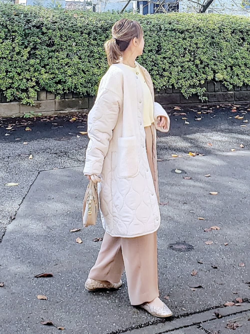 ホワイト系のその他アウター、ベージュ系のスウェット、ベージュ系のその他パンツを着用したレディースの冬コーディネートの2枚目の写真