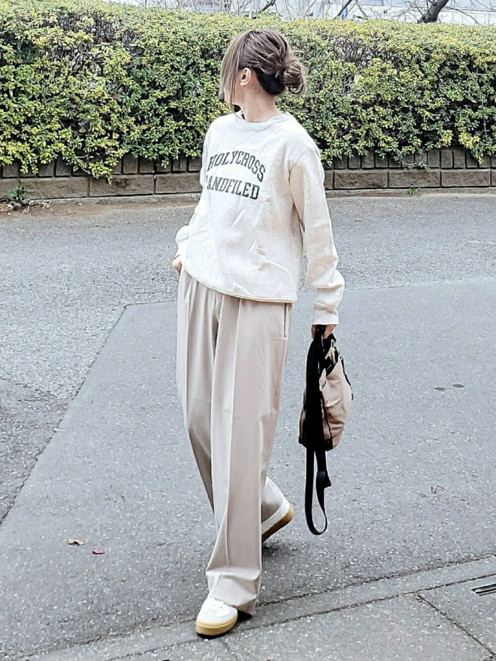 ベージュ系のスウェット、ベージュ系のパンツ、ブラウン系のショルダーバッグを着用したレディースの冬コーディネートの2枚目の写真