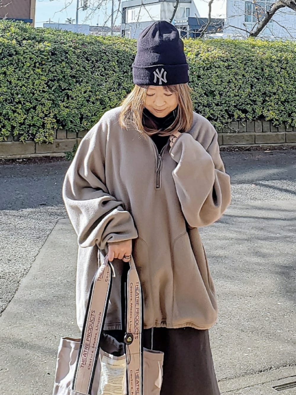 ブラウン系のトップス、グレー系のスカート、ベージュ系のトートバッグを着用したレディースの冬コーディネートの4枚目の写真