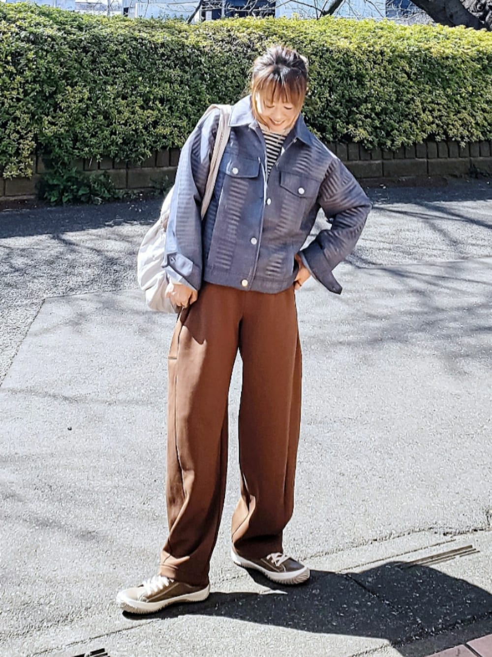 ブルー系のデニムジャケット、ブラック系のTシャツ/カットソー、ブラウン系のスウェットパンツを着用したレディースの春コーディネートの3枚目の写真