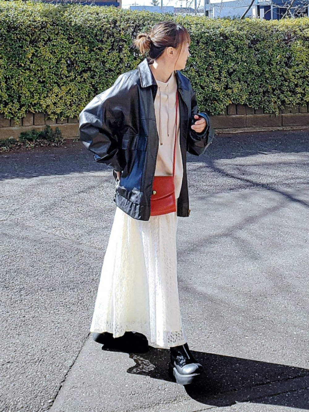 ブラック系のブルゾン、ベージュ系のスウェット、ホワイト系のスカートを着用したレディースの春コーディネートの2枚目の写真