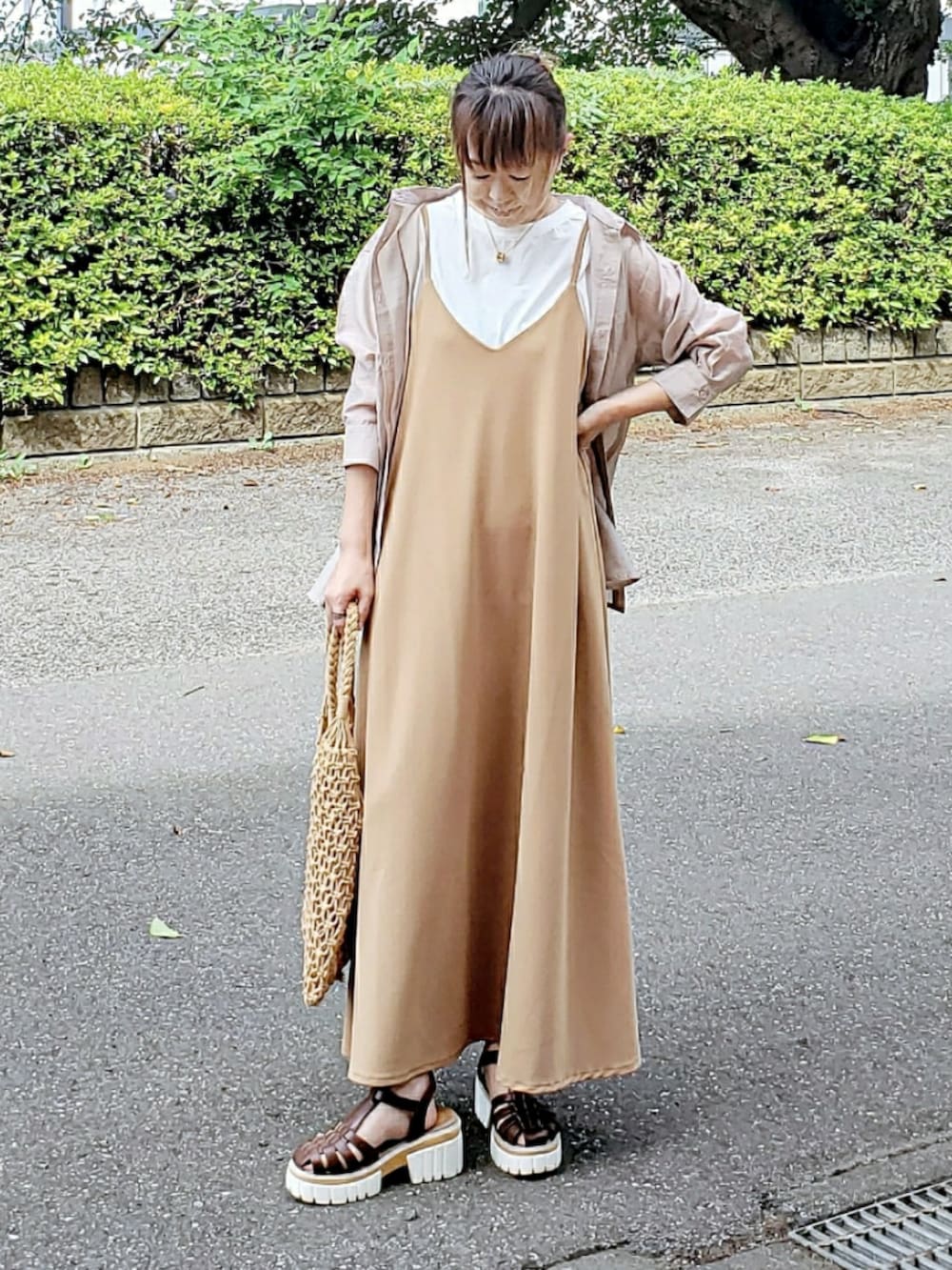 ベージュ系のシャツ/ブラウス、ベージュ系のジャンパースカート、ブラウン系のサンダルを着用したレディースの夏コーディネートの2枚目の写真