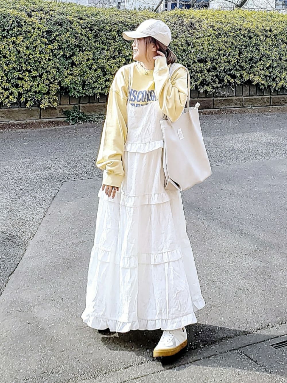 イエロー系のスウェット、ホワイト系のワンピース、ホワイト系のトートバッグを着用したレディースの春コーディネートの3枚目の写真