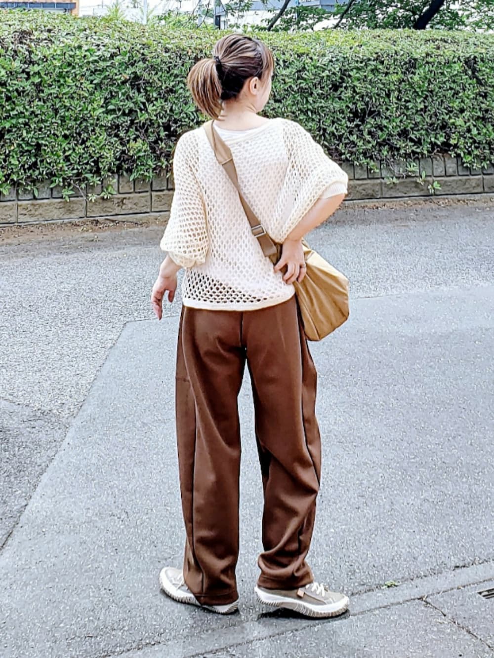 ベージュ系のニット/セーター、ブラウン系のスウェットパンツ、グレー系のスニーカーを着用したレディースの夏コーディネートの3枚目の写真
