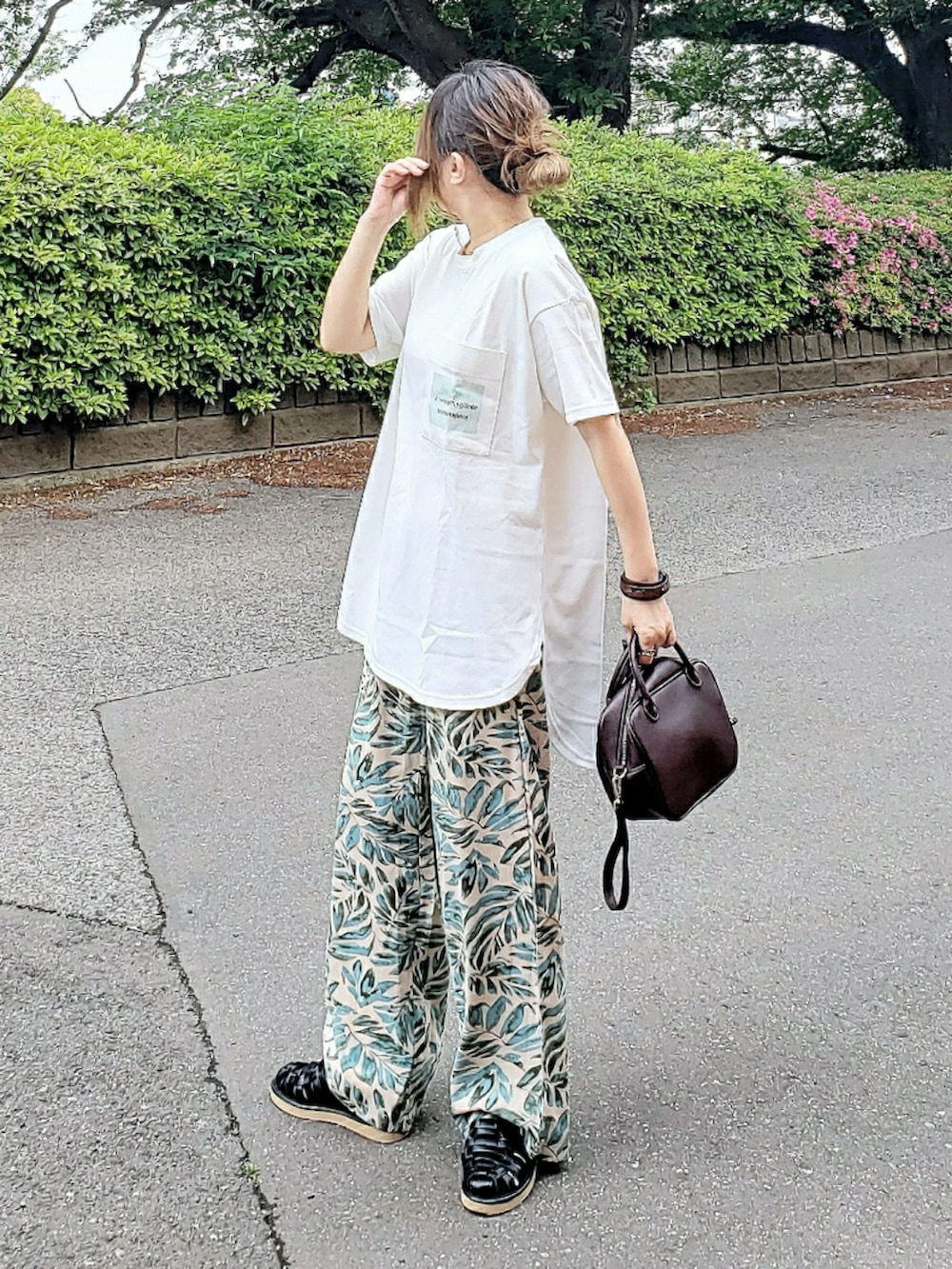 ホワイト系のTシャツ/カットソー、グリーン系のその他パンツ、ブラウン系のボストンバッグを着用したレディースの春コーディネートの2枚目の写真