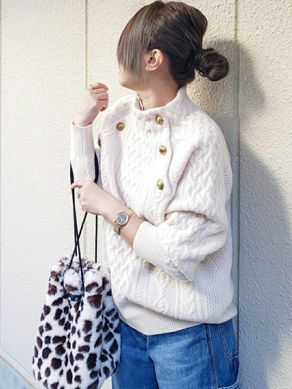 ベージュ系のニット/セーター、ブルー系のデニムパンツ、ホワイト系のスニーカーを着用したレディースの冬コーディネートの2枚目の写真