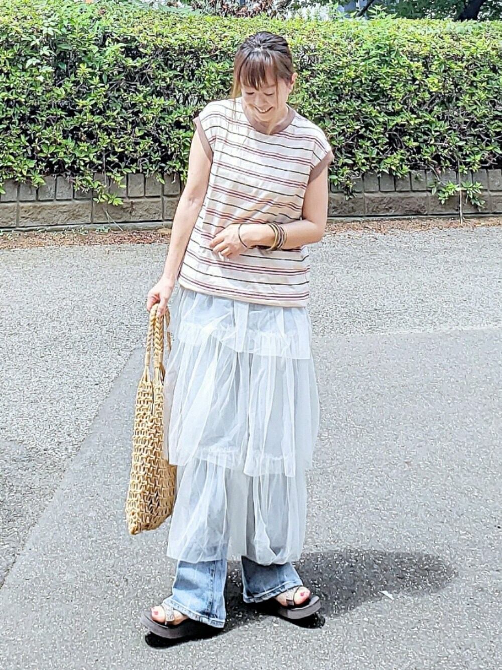 ホワイト系のTシャツ/カットソー、ホワイト系のスカート、ブルー系のデニムパンツを着用したレディースの夏コーディネートの3枚目の写真