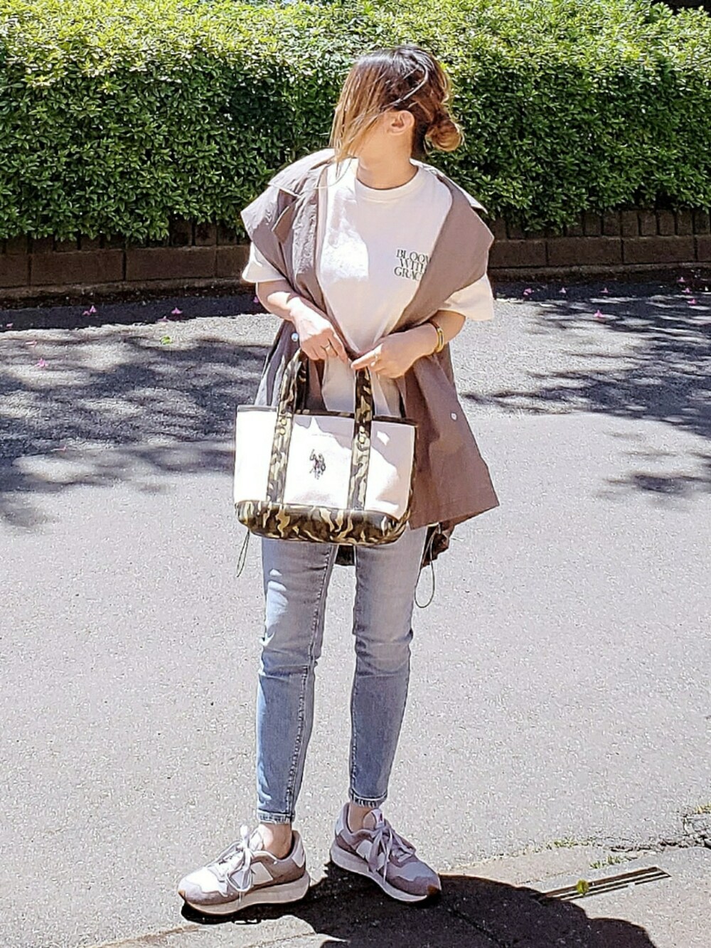 ホワイト系のトートバッグ、グレー系のミリタリージャケット、ホワイト系のTシャツ/カットソーを着用したレディースの春コーディネートの2枚目の写真