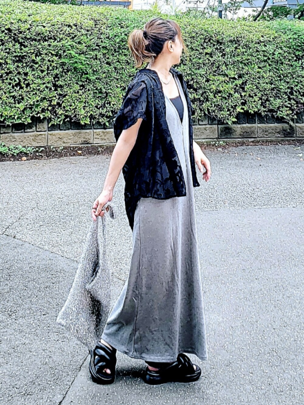 グレー系のワンピース、ブラック系のサンダル、シルバー系のショルダーバッグを着用したレディースの夏コーディネートの3枚目の写真