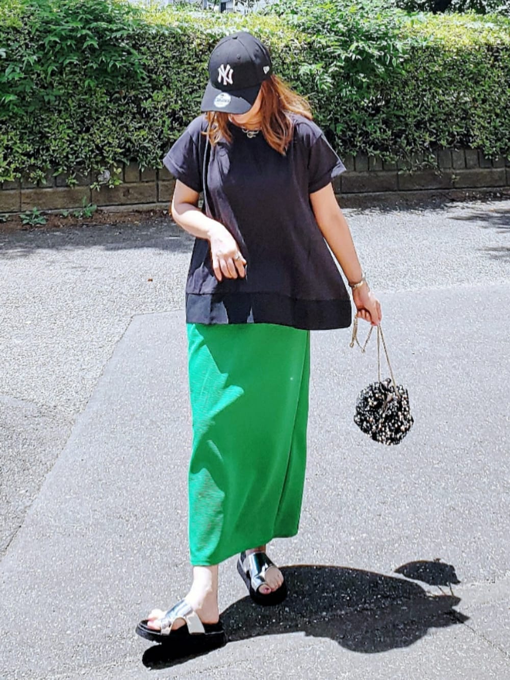 ブラック系のTシャツ/カットソー、グリーン系のスカート、シルバー系のサンダルを着用したレディースの夏コーディネートの3枚目の写真