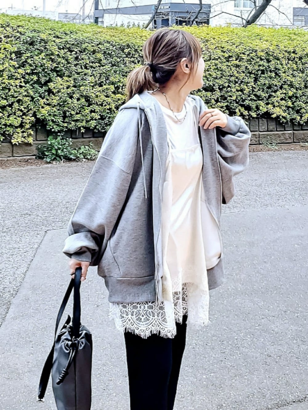 ホワイト系のキャミソール、グレー系のパーカー、ブラック系のその他パンツを着用したレディースの春コーディネートの4枚目の写真