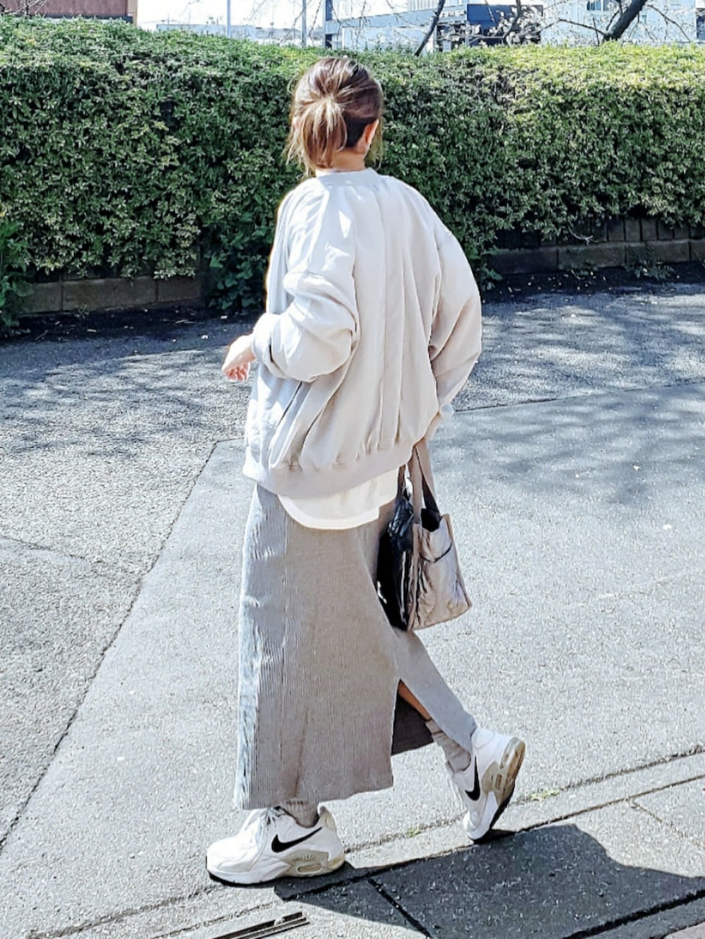グリーン系のブルゾン、ホワイト系のTシャツ/カットソー、グレー系のスカートを着用したレディースの春コーディネートの2枚目の写真