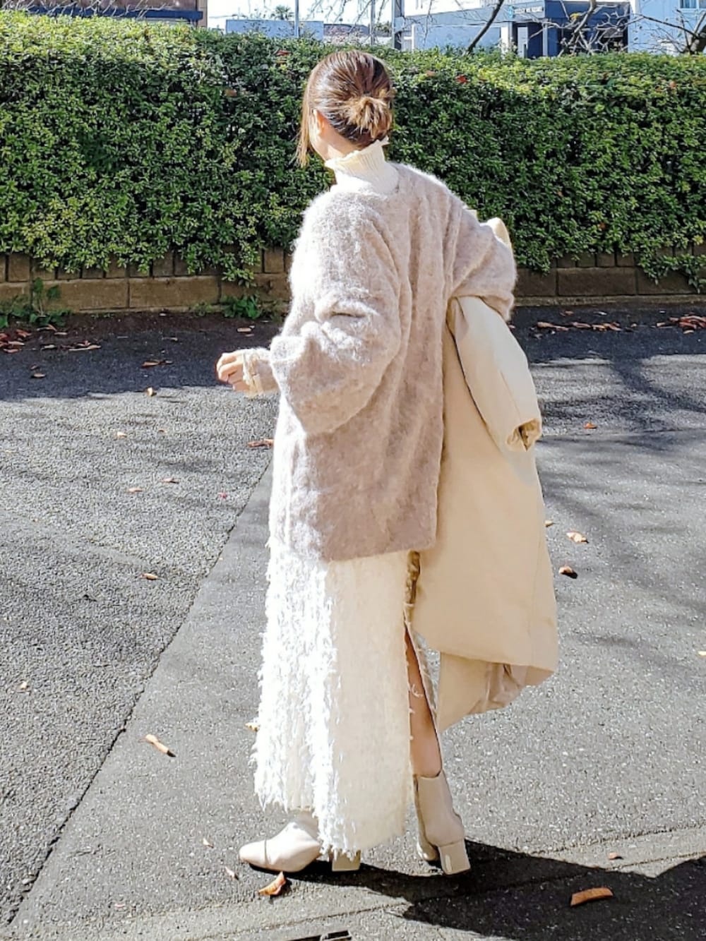 ベージュ系のダウンジャケット/コート、ブラウン系のカーディガン/ボレロ、ホワイト系のニット/セーターを着用したレディースの冬コーディネートの3枚目の写真