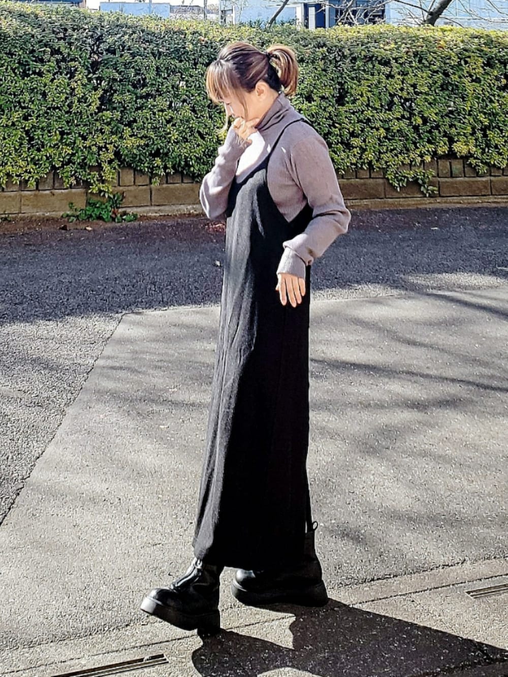 ブラウン系のダウンジャケット/コート、グレー系のニット/セーター、ブラック系のワンピースを着用したレディースの冬コーディネートの3枚目の写真