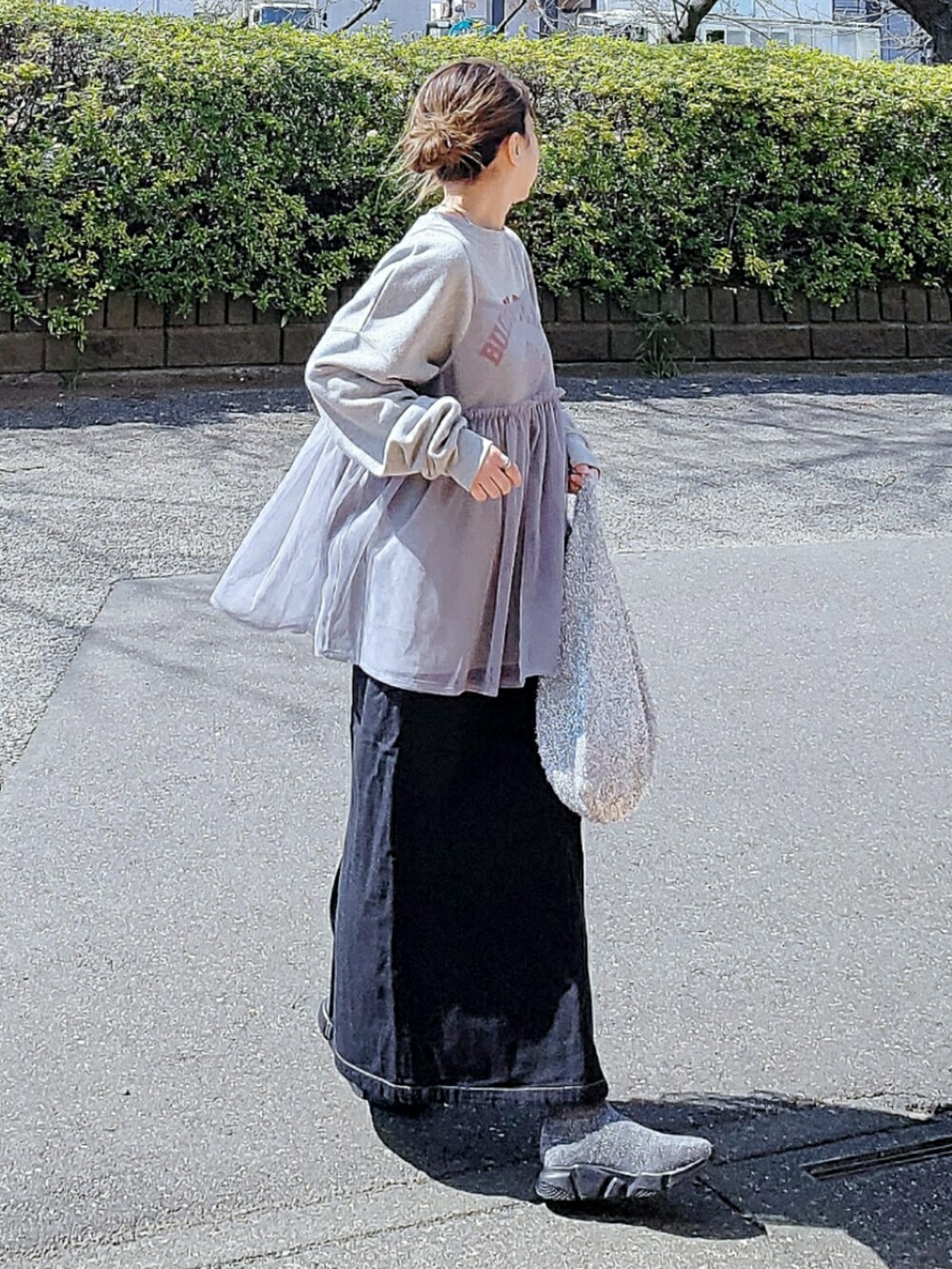 グレー系のスウェット、グレー系のキャミソール、ブラック系のスカートを着用したレディースの春コーディネートの2枚目の写真