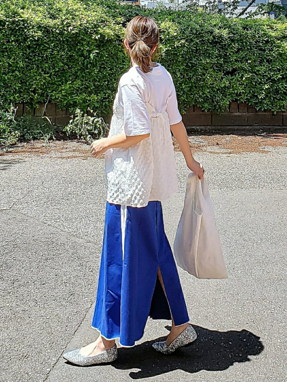 ホワイト系のシャツ/ブラウス、ブラック系のTシャツ/カットソー、ブルー系のスカートを着用したレディースの春コーディネートの3枚目の写真