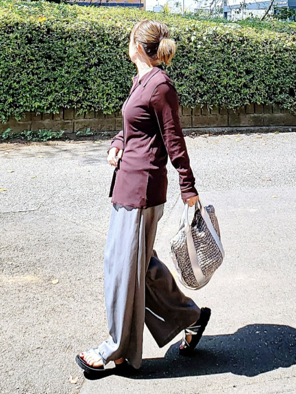 ブラウン系のカーディガン/ボレロ、グレー系のスラックス、グレー系のショルダーバッグを着用したレディースの秋コーディネートの2枚目の写真