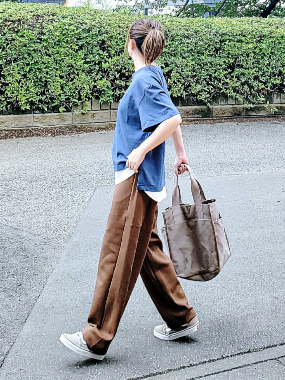 ブルー系のTシャツ/カットソー、ブラウン系のスウェットパンツ、ベージュ系のトートバッグを着用したレディースの夏コーディネートの2枚目の写真
