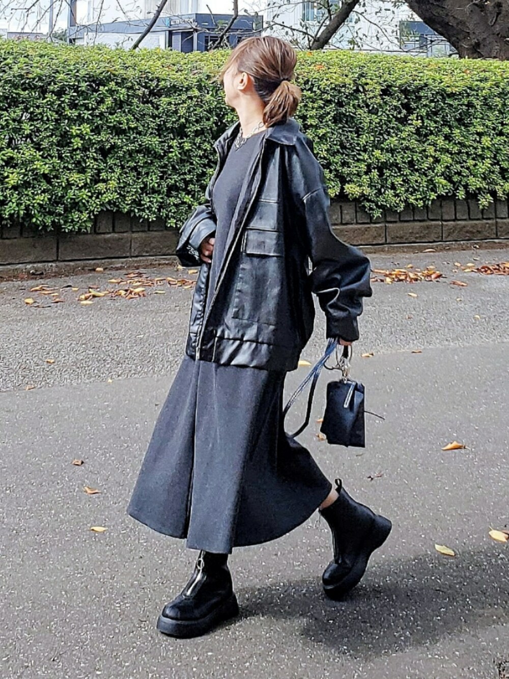 グレー系のワンピース/ドレス、ブラック系のブルゾン、ブルー系のショルダーバッグを着用したレディースの冬コーディネートの2枚目の写真