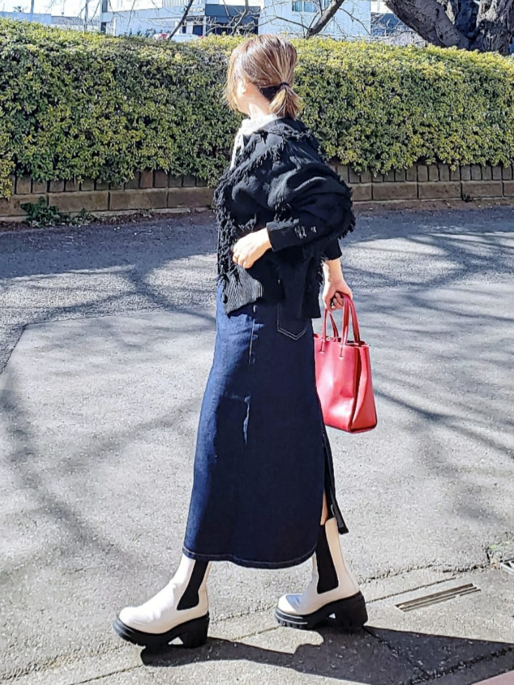 ブルー系のデニムスカート、ホワイト系のシャツ/ブラウス、レッド系のトートバッグを着用したレディースの冬コーディネートの3枚目の写真