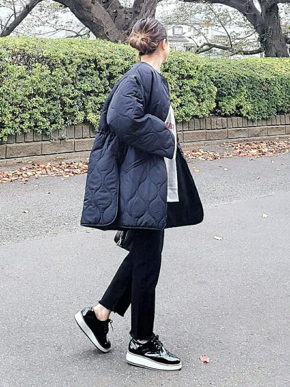 ブラック系のノーカラーコート、グレー系のスウェット、ブラック系のその他パンツを着用したレディースの秋コーディネートの2枚目の写真