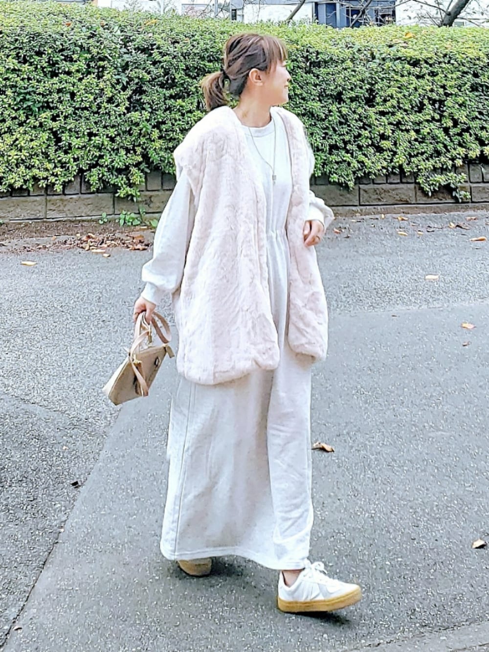 ホワイト系のベスト、ベージュ系のワンピース、ベージュ系のショルダーバッグを着用したレディースの冬コーディネートの2枚目の写真