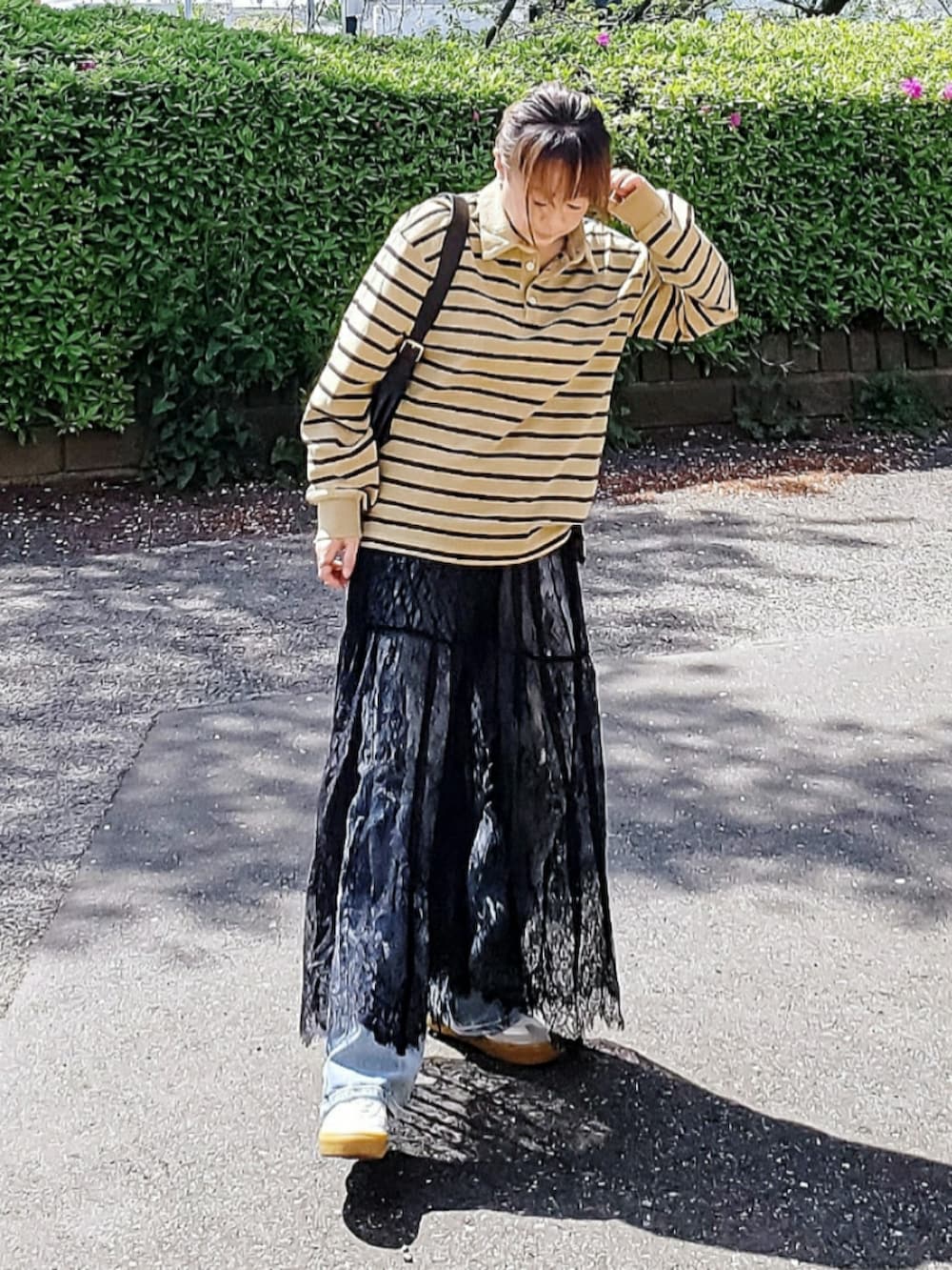 イエロー系のTシャツ/カットソー、ブラック系のスカート、ブルー系のデニムパンツを着用したレディースの春コーディネートの3枚目の写真