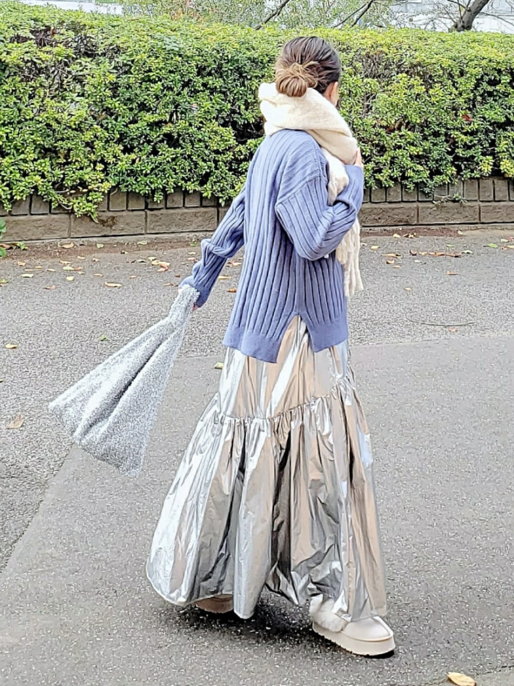 ブルー系のニット/セーター、シルバー系のスカート、ベージュ系のスリッポンを着用したレディースの冬コーディネートの2枚目の写真